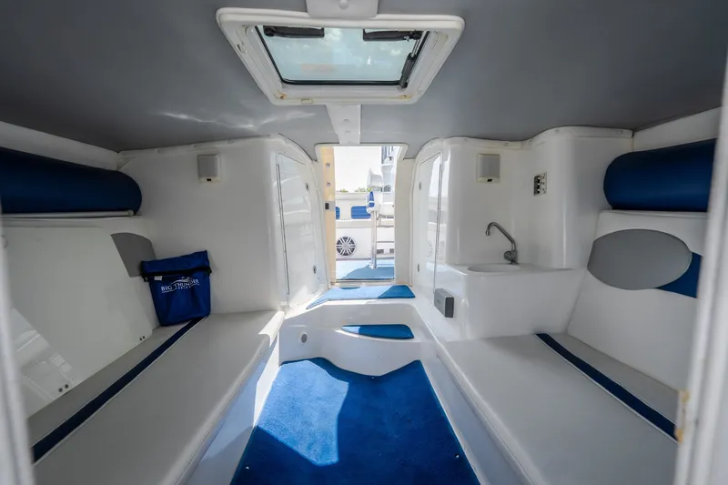 Slide: The Image of Interior of 2012 Nautical NRG 30 boat, featuring blue and white seating and a compact sink. - 30