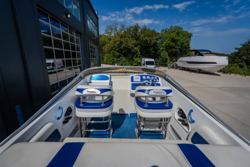 Slide: The Image of Interior of a 2012 Nautical NRG 30 boat with blue and white seating. - 11