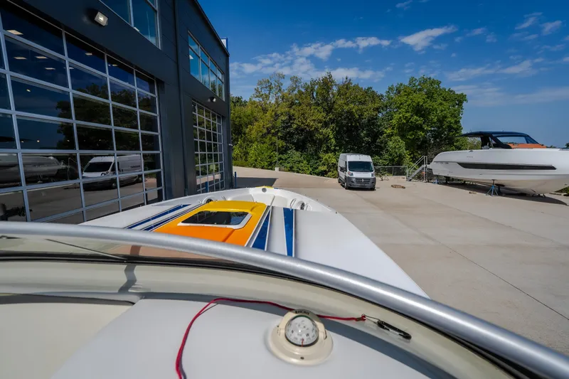 Slide: The Image of 2012 Nautical NRG 30 boat docked near a modern building under a clear blue sky. - 16