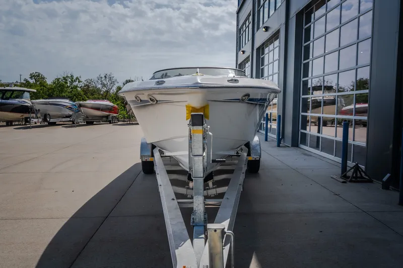 Slide: The Image of Front view of a 2012 Nautical NRG 30 boat on a trailer outside a showroom. - 8