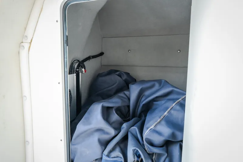 Slide: The Image of Storage compartment of Nautical NRG 30 boat, featuring blue fabric and wiring, 2012 model. - 32