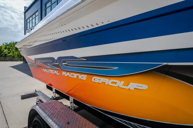 Slide: The Image of Nautical NRG 30 boat, 2012 model, with vibrant orange and blue racing design. - 64