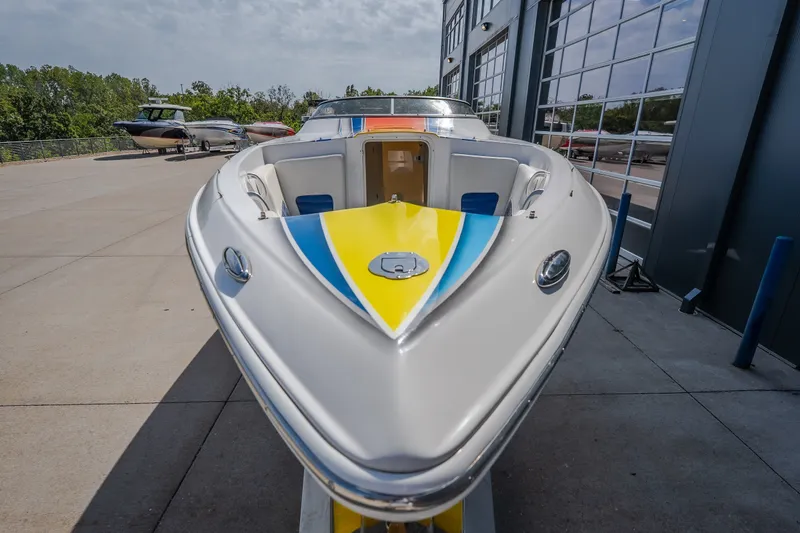 Slide: The Image of Nautical NRG 30 boat, 2012 model, docked outdoors with vibrant yellow and blue accents. - 26