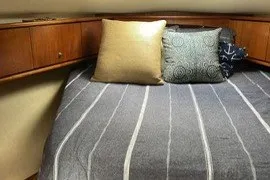 Slide: The Image of 2009 Tiara Yachts 3900 Sovran cabin interior with cozy bedding and decorative pillows. - 29