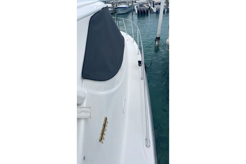 Slide: The Image of 2009 Tiara Yachts 3900 Sovran docked, showcasing sleek white exterior and marina view. - 21