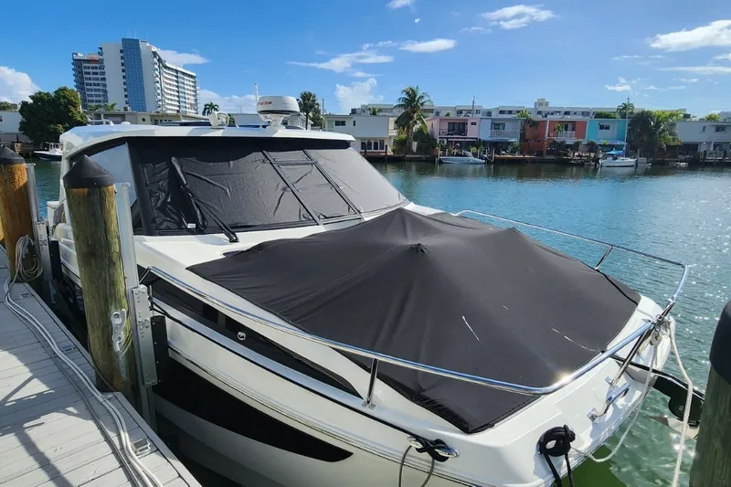 Slide: The Image of 2024 Aquila 36 Sport yacht docked, covered, with waterfront view and modern buildings. - 18