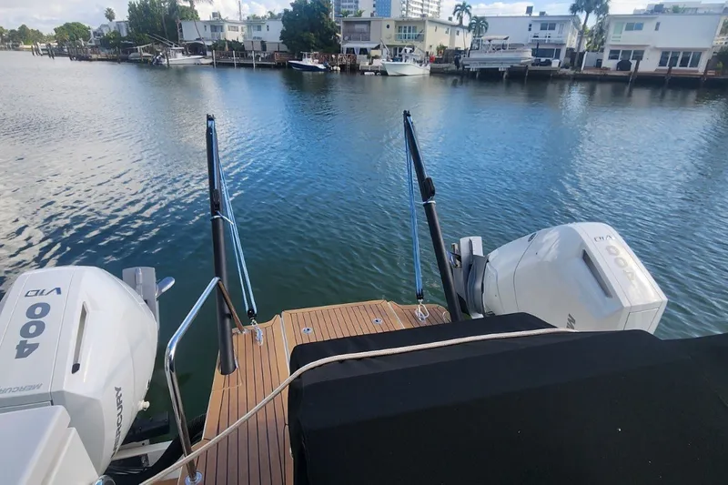 Slide: The Image of 2024 Aquila 36 Sport boat with dual Mercury 400 engines on a calm waterfront. - 15