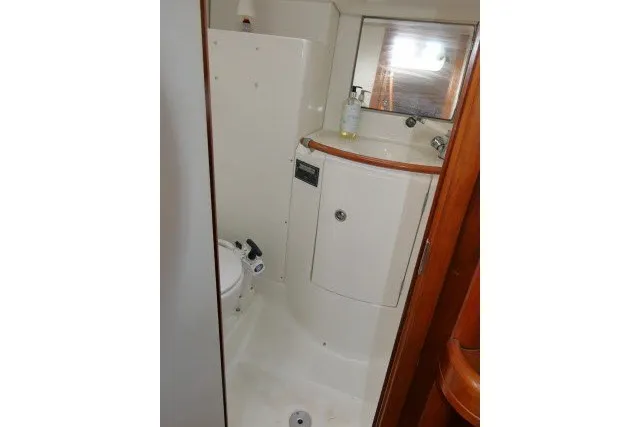 Slide: The Image of 1999 Beneteau 411 yacht bathroom with compact design and wooden accents. - 29
