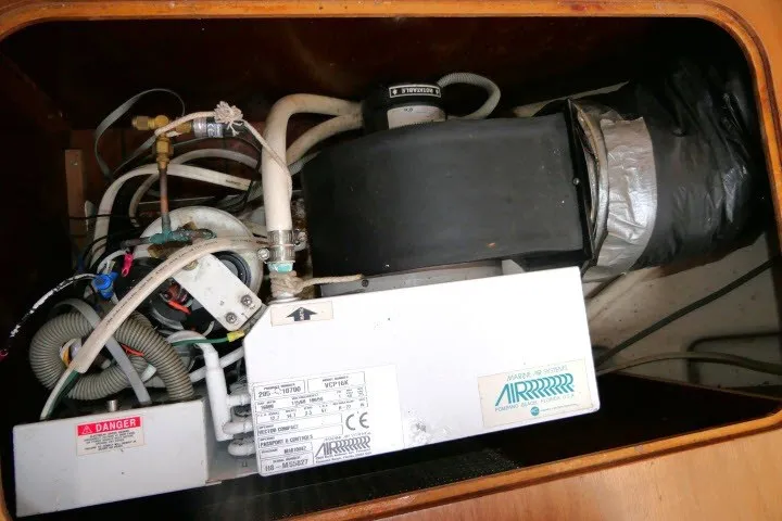 Slide: The Image of Air conditioning unit in a 1999 Beneteau 411 sailboat, showing wiring and ductwork. - 72