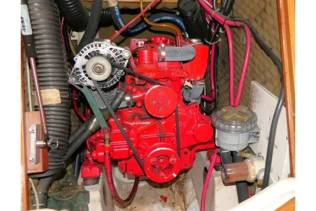 Slide: The Image of Engine compartment of a 1999 Beneteau 411 sailboat, featuring a red marine engine. - 66