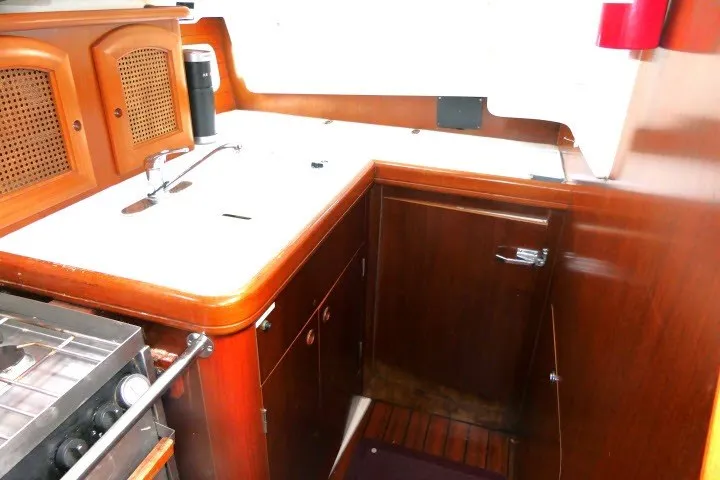 Slide: The Image of 1999 Beneteau 411 yacht kitchen with wooden cabinetry and compact design. - 17