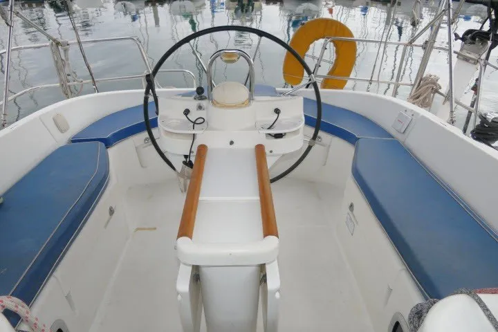Slide: The Image of Cockpit of 1999 Beneteau 411 sailboat with blue seating and steering wheel. - 42