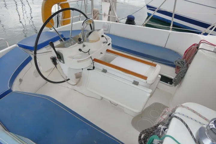Slide: The Image of Cockpit of 1999 Beneteau 411 sailboat with blue seating and steering wheel. - 44