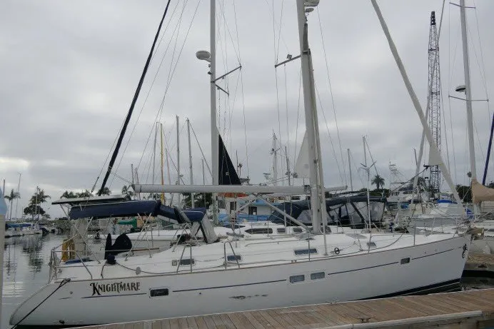 Slide: The Image of 1999 Beneteau 411 sailboat docked at marina under cloudy sky. - 83