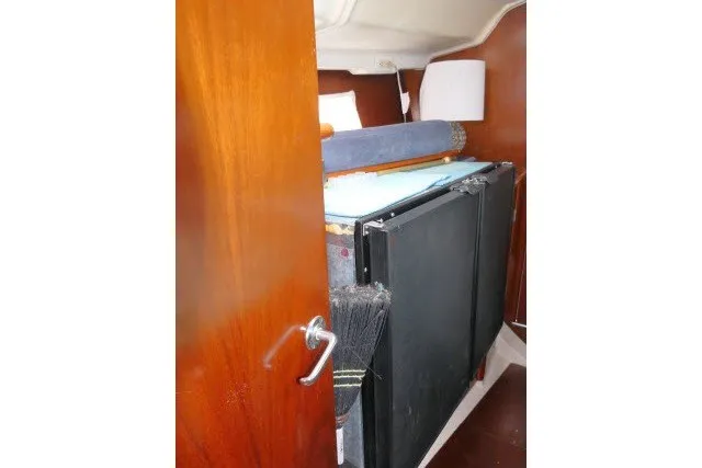 Slide: The Image of Interior cabin view of a 1999 Beneteau 411 sailboat with wooden door and storage. - 36
