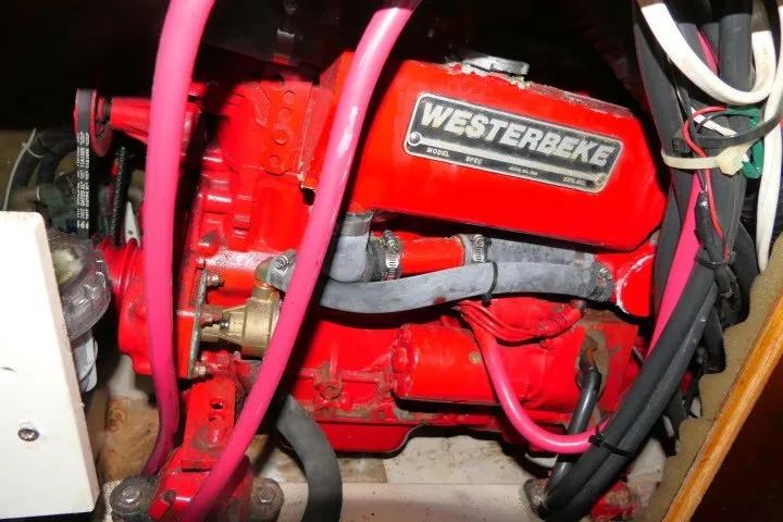 Slide: The Image of Red Westerbeke engine in a 1999 Beneteau 411 sailboat, featuring visible hoses and wiring. - 68