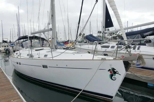 Slide: The Image of 1999 Beneteau 411 sailboat docked at marina, featuring sleek white hull and nautical design. - 78