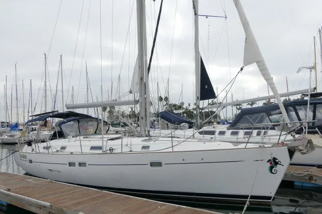 The Image of 1999 Beneteau 411 sailboat docked at marina, overcast sky, multiple masts in background. - 1