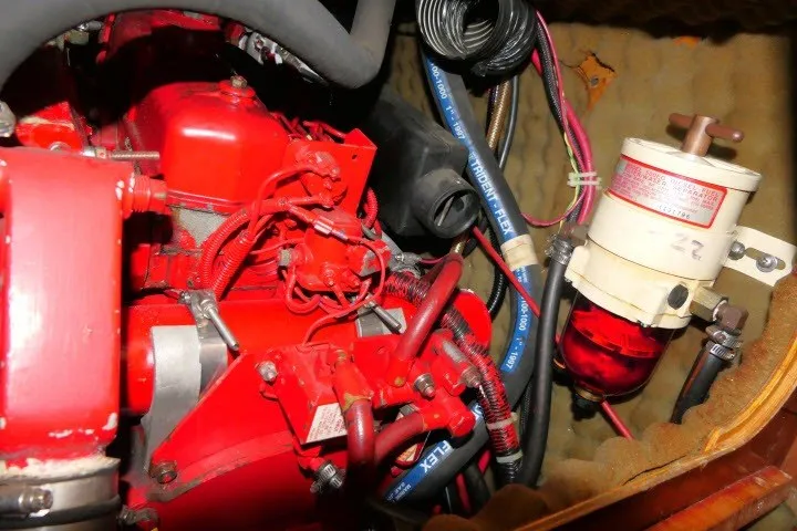 Slide: The Image of Engine compartment of a 1999 Beneteau 411 sailboat, featuring red engine components. - 67