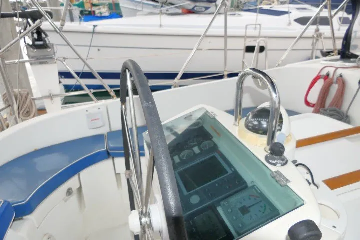 Slide: The Image of Cockpit of a 1999 Beneteau 411 sailboat with navigation instruments and steering wheel. - 49