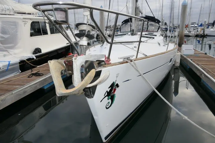 Slide: The Image of 1999 Beneteau 411 sailboat docked at marina, featuring sleek design and nautical emblem. - 79