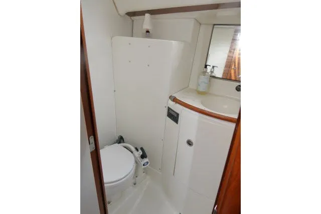 Slide: The Image of Bathroom interior of 1999 Beneteau 411 yacht, featuring compact toilet and sink. - 30