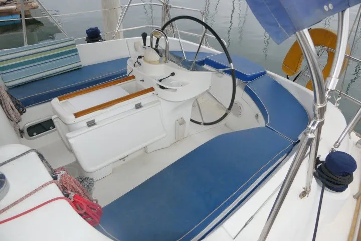 Slide: The Image of Cockpit of a 1999 Beneteau 411 sailboat with blue seating and steering wheel. - 46