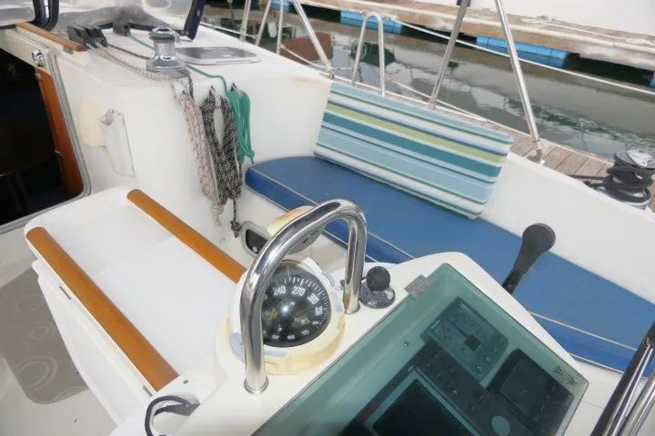 Slide: The Image of Cockpit of 1999 Beneteau 411 sailboat with compass, seating, and navigation equipment. - 48