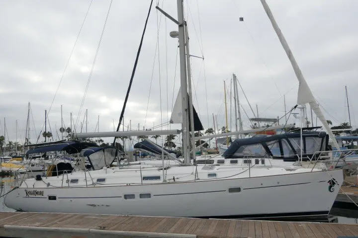 Slide: The Image of 1999 Beneteau 411 sailboat docked at marina under cloudy sky. - 82