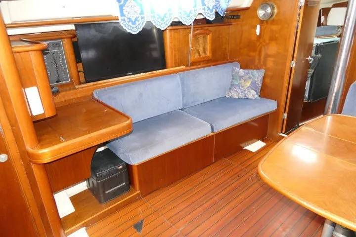 Slide: The Image of Interior of 1999 Beneteau 411 yacht with blue sofa and wooden furnishings. - 5