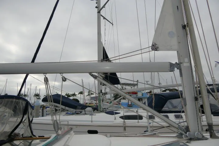 Slide: The Image of 1999 Beneteau 411 sailboat docked, showcasing mast and rigging under cloudy skies. - 60