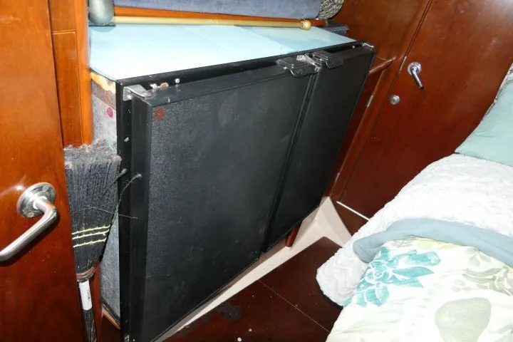 Slide: The Image of Interior of a 1999 Beneteau 411 sailboat with storage compartment and broom. - 37