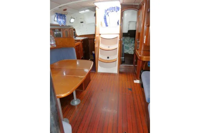 Slide: The Image of Interior of 1999 Beneteau 411 sailboat with wooden flooring and dining area. - 11