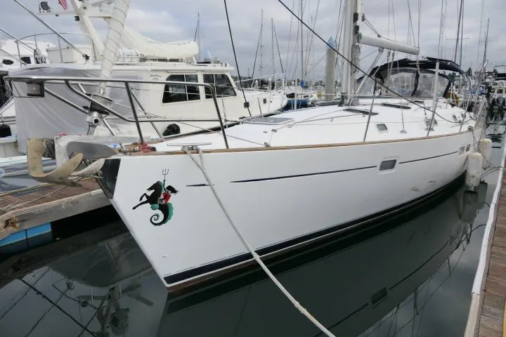 Slide: The Image of 1999 Beneteau 411 sailboat docked at marina, featuring sleek white hull and nautical design. - 80