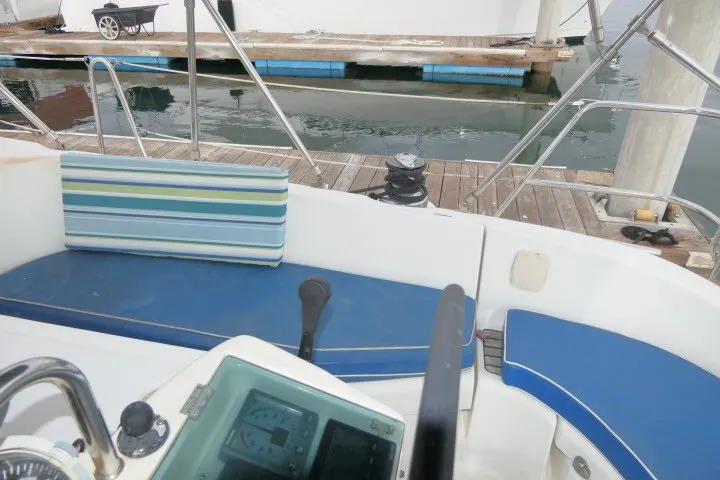 Slide: The Image of Cockpit of 1999 Beneteau 411 sailboat with blue seating and striped cushion. - 47