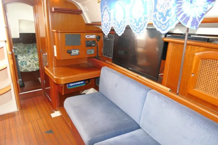 Slide: The Image of Interior of 1999 Beneteau 411 yacht with blue sofa and wooden cabinetry. - 12