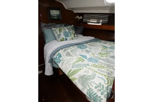 Slide: The Image of Cozy cabin bedroom in 1999 Beneteau 411 sailboat with floral bedding and wooden accents. - 33