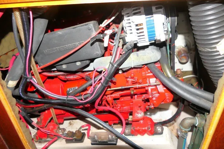 Slide: The Image of Engine compartment of a 1999 Beneteau 411 sailboat, featuring red mechanical components. - 69