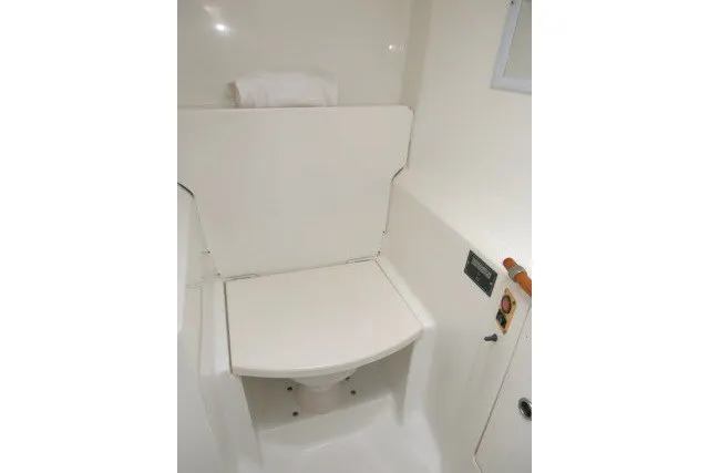 Slide: The Image of 1999 Beneteau 411 yacht bathroom with compact white toilet and storage. - 39
