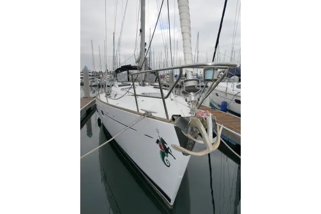 Slide: The Image of Sailboat Beneteau 411, 1999 model, docked at marina with seahorse emblem. - 77