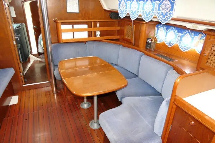 Slide: The Image of Interior of 1999 Beneteau 411 sailboat with blue seating and wooden table. - 7