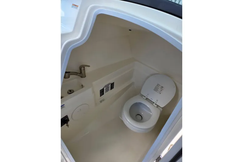 Slide: The Image of Interior of 2020 Boston Whaler 230 Vantage boat showing compact marine toilet. - 11