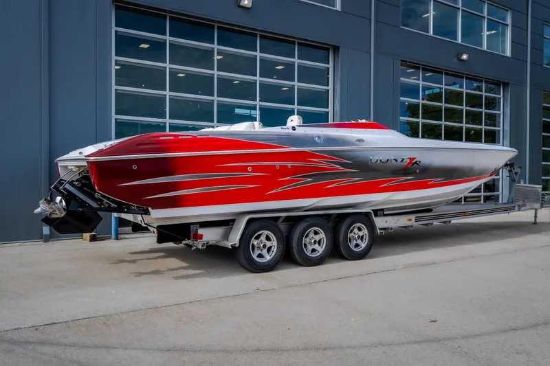 Slide: The Image of 2005 Donzi 35 ZR speedboat with red and silver design on a trailer. - 6