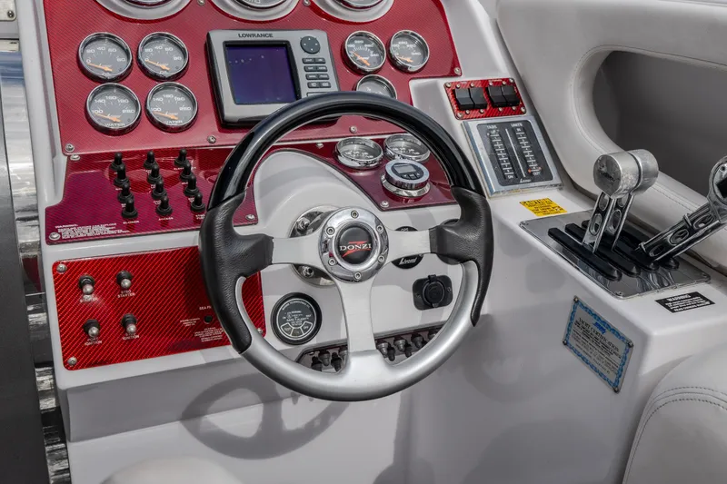 Slide: The Image of 2005 Donzi 35 ZR boat dashboard with steering wheel, gauges, and controls. - 24