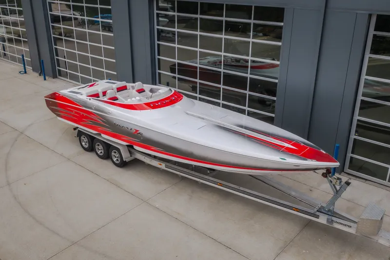 Slide: The Image of 2005 Donzi 35 ZR speedboat with red and silver design on a trailer. - 53