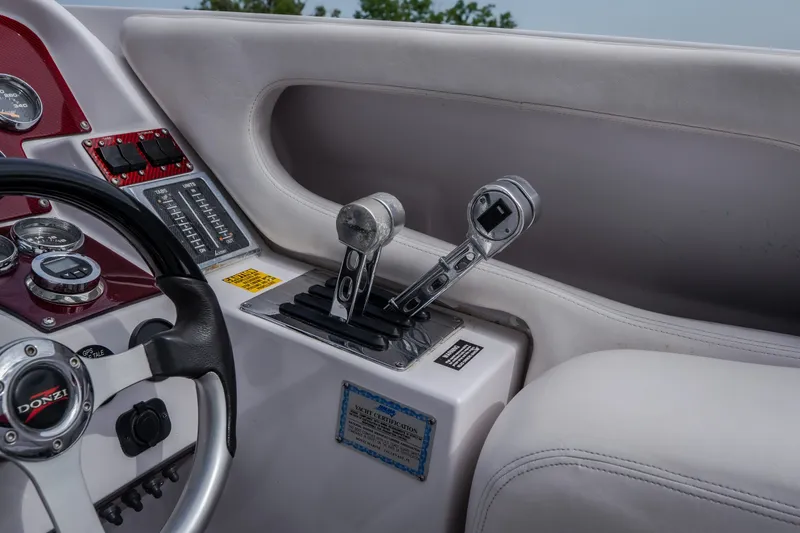 Slide: The Image of 2005 Donzi 35 ZR boat cockpit with steering wheel and throttle controls. - 25