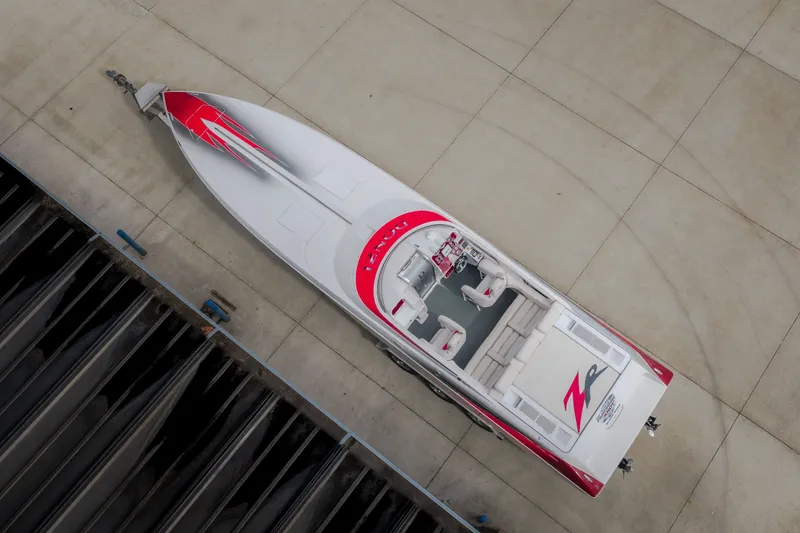 Slide: The Image of Overhead view of a 2005 Donzi 35 ZR speedboat with red accents on concrete. - 56
