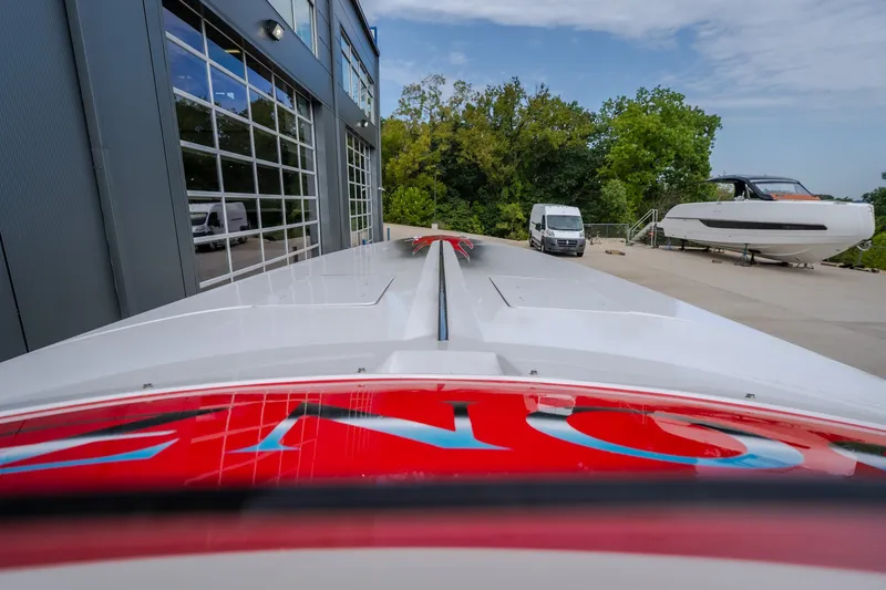 Slide: The Image of 2005 Donzi 35 ZR boat parked near a modern building and trees. - 43
