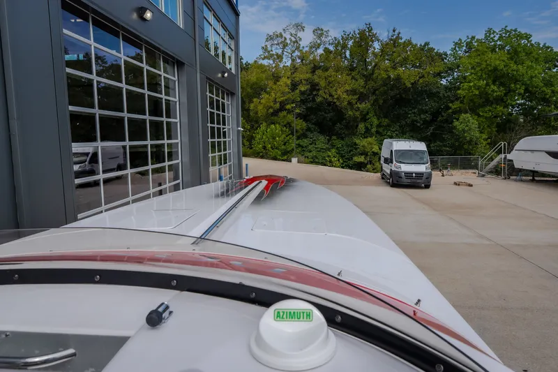 Slide: The Image of 2005 Donzi 35 ZR boat parked near a modern building and greenery. - 28
