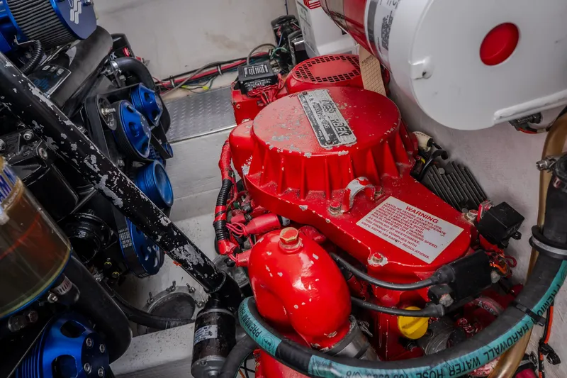 Slide: The Image of Engine compartment of a 2005 Donzi 35 ZR boat, featuring red and blue components. - 49
